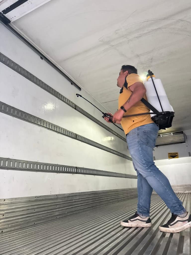 Spray sanitization on walls and ceiling inside a refrigerated trailer